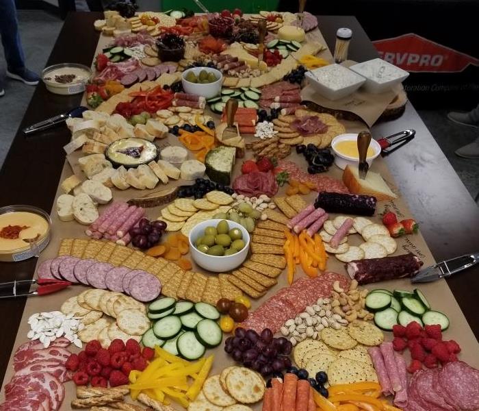 a board with several cheeses and fruits on it